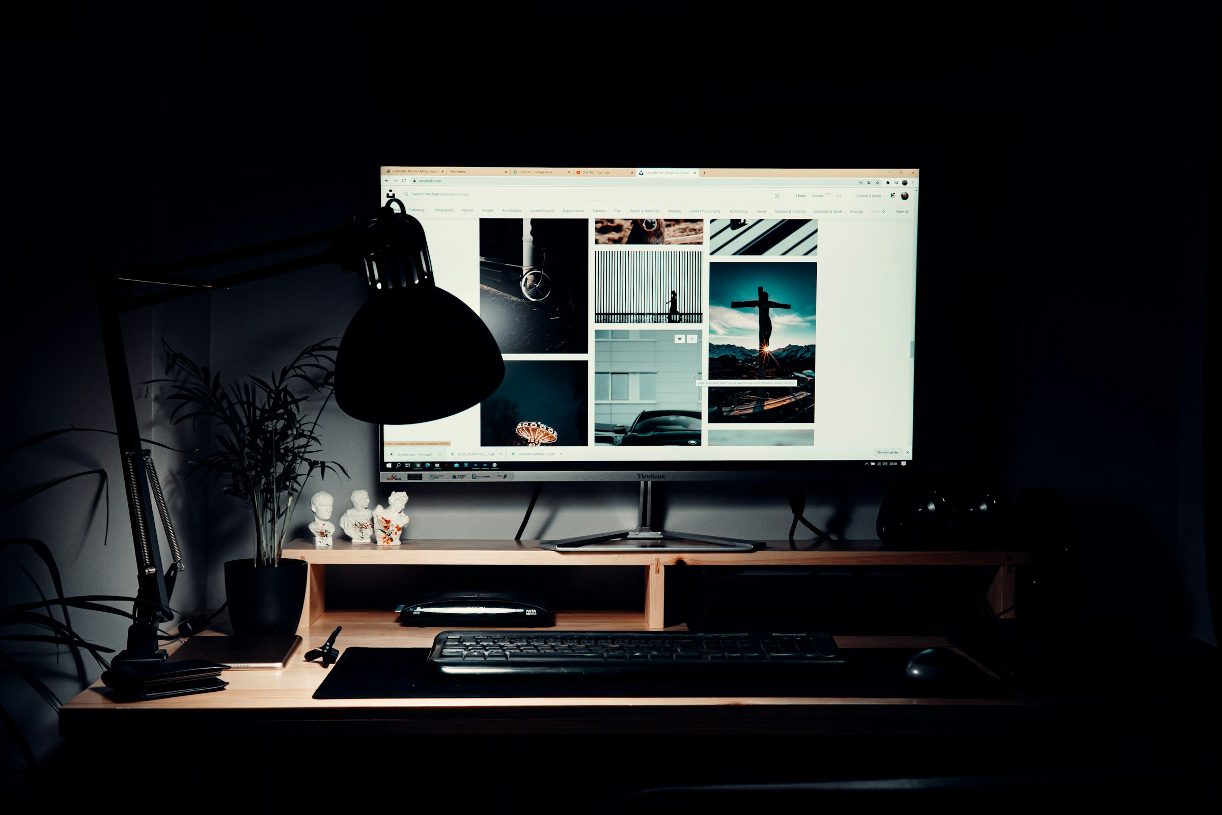 A designer's desktop with a large monitor displaying visual work